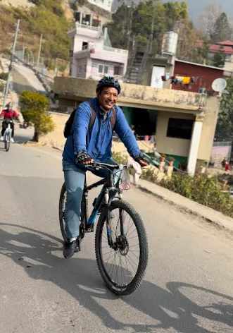 Shivaram cycling outdoors during Novelty x Astra Fitness fitness run.